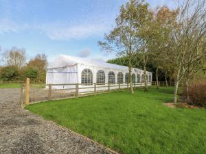 una tienda blanca en un campo con una valla en Pompian Lodge, en Bretherton