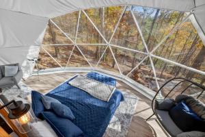 een tent met een bed en stoelen erin bij Glamping Dome w Fire Pit WiFi King Bed & Bath in Wardensville