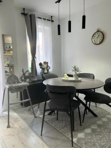 a dining room with a table and chairs and a clock at Vila Vedrana Apartman Nedeljkovic in Brzeće +12 photos