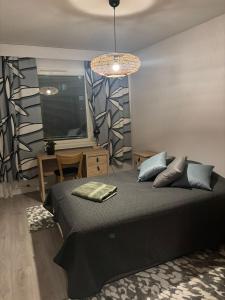 a bedroom with a black bed and a table at Apartment for five near Railway station in Rovaniemi +1 photo