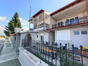 a house with a fence in front of it at Polys Apartment and Paraskevi studio with view in Ptolemaida