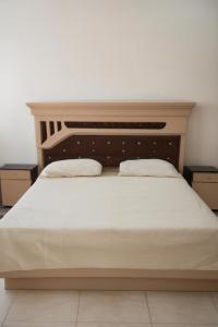 a bed with two pillows on top of it at السعادة للشقق المفروشة 