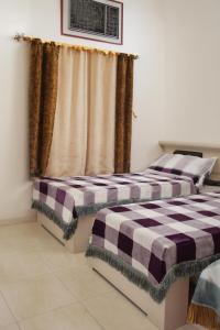 two beds sitting next to each other in a room at السعادة للشقق المفروشة  +8 photos