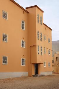an orange building with white windows at السعادة للشقق المفروشة 