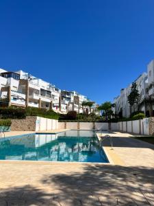 フニデクにあるAlcudia Smir Complexの一部のアパートメントビルの前にスイミングプールがあります。