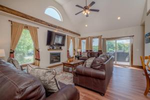 a living room with leather furniture and a ceiling fan at Hickory Hideaway with Communal Pool Access in Hollister