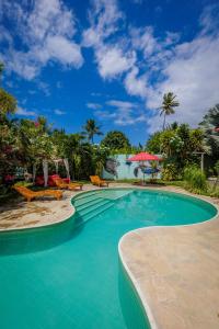ein Swimmingpool mit Stühlen und Sonnenschirmen in einem Resort in der Unterkunft Xainã Pousada de Charme in Cumbuco