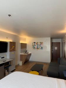 巴吞鲁日巴敦罗吉机场麦克罗特套房酒店的一间带床和客厅的酒店房间