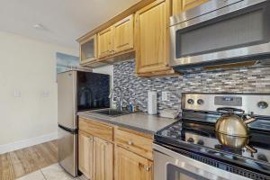 a kitchen with wooden cabinets and a stove top oven at The View II at Sheepscot River in Fort Edgecomb