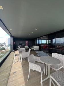 a room with tables and chairs on a balcony at Tolive One - Ilha do Leite, Recife in Recife