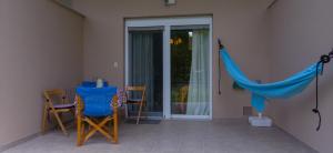 eine Terrasse mit Stühlen und einem Tisch und einem blauen Netz in der Unterkunft Orma, pet friendly retreat studio in Orma