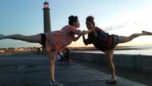 dos personas bailando en la playa con el faro en el fondo en Andorinho Sea View Apartment, en Margate