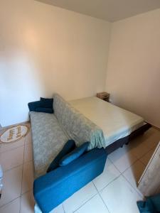 a bedroom with a bed and a blue couch at Cristian in Livry-Gargan +1 photo