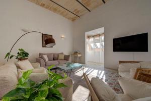 a living room with a couch and a tv at Villa Josette with Pool Table and Garden by Haven and Keys Malta in Tal-Għoqod