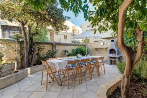 a table with chairs and an umbrella on a patio at Villa Josette with Pool Table and Garden by Haven and Keys Malta in Tal-Għoqod