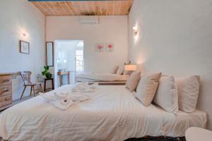 a bedroom with a large white bed with flowers on it at Villa Josette with Pool Table and Garden by Haven and Keys Malta in Tal-Għoqod