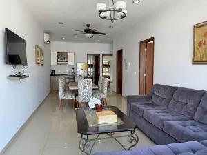 a living room with a blue couch and a table at Depa a unas Calles de la Playa By GPSRentas in Isla Venados