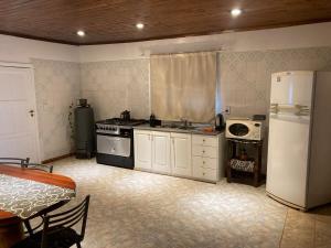 a kitchen with a refrigerator and a stove and a microwave at Casa bulgara boutique in Aristóbulo del Valle +11 photos