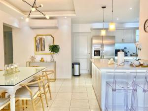a kitchen with white cabinets and a table and chairs at Stylish 3BR Condo, Full AC, Wi-Fi in Santo Domingo