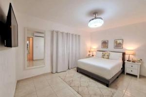 a bedroom with a bed and a flat screen tv at Stylish 3BR Condo, Full AC, Wi-Fi in El Seis
