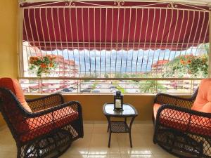 two chairs and a table in front of a large window at Stylish 3BR Condo, Full AC, Wi-Fi in El Seis