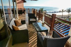 a balcony with chairs and a table and the ocean at Beachfront in a peaceful Resort 8mi from Puerto Escondido in Puerto Escondido