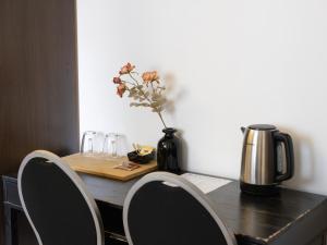 a table with two chairs and a vase with flowers at St Christopher's Inn Bruges - The Bauhaus in Bruges