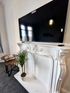 a white table with a tv on top of it at Comfort in the East in Glasgow