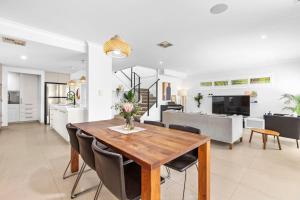 a dining room and kitchen with a table and chairs at Coastal Retreat in Burns Beach in Kinross
