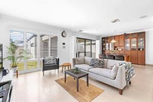 a living room with a couch and a table at Coastal Retreat in Burns Beach in Kinross