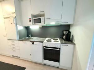 MasalaにあるConvenient Studio for 1の白いキャビネットとコンロ付きオーブンを備えたキッチン