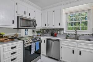 a kitchen with white cabinets and stainless steel appliances at Lexington Leisure House- 4BR in Lexington