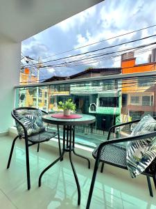 a balcony with a table and two chairs and a window at Apartamento Ideal y Tranquilo in Sabaneta