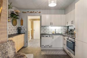 a kitchen with white cabinets and a stove top oven at TH963- Cozy Ski-in out apartment in Trysil in Trysil