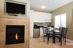a living room with a fireplace and a table and chairs at Monterey Peninsula Inn in Pacific Grove