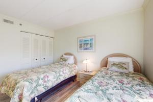 two beds in a bedroom with white walls at Waikiki 406 in Ocean City +16 photos
