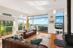 a living room with a couch and a television at Sunrise By The Sea in Torquay