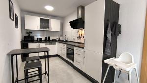 a kitchen with white cabinets and a table and stool at Tolle Lage - modern - zentral gelegen - 2 Zimmer Apartment in Horb am Neckar