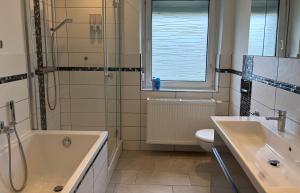 a bathroom with a tub and a sink and a shower at Gästewohnung Rosengarten- Damaschke Straße in Halle an der Saale