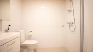a white bathroom with a toilet and a shower at Convenient Apartment for 4 with Sauna in Espoo