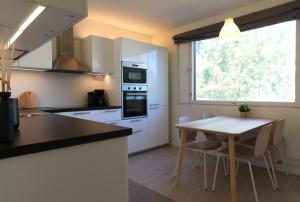 a kitchen with a table and a table and a window at Central and Spacious Apartment for 4 with Sauna in Kirkkonummi