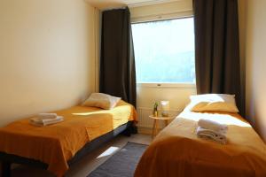 two beds in a small room with a window at Central and Spacious Apartment for 4 with Sauna in Kirkkonummi