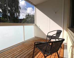 two chairs on a balcony with a large window at Central and Spacious Apartment for 4 with Sauna in Kirkkonummi