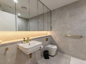 a bathroom with a sink and a toilet and a mirror at Brand new 2BR APT in Castle Hill in Castle Hill +13 photos