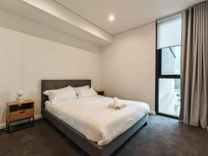 a bedroom with a large bed and a window at Brand new 2BR APT in Castle Hill in Castle Hill