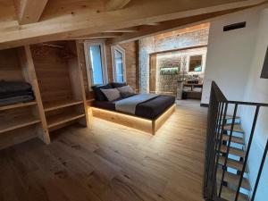 a bedroom with a bed and a staircase in a room at Il giardino dei larici in Selvino