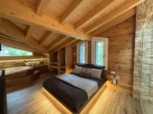 a bedroom with a large bed in a log cabin at Il giardino dei larici in Selvino