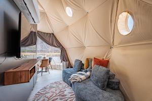 a living room with a couch in a yurt at Once-in-a-Lifetime Escape Celestine Hot Tub Between Two State Parks in Pipestem