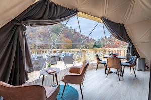 a tent with chairs and tables and a large window at Once-in-a-Lifetime Escape Celestine Hot Tub Between Two State Parks in Pipestem