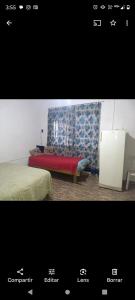 een slaapkamer met een bank en een stoel in een kamer bij Los patos in Capilla del Monte